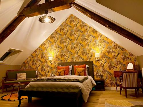 a bedroom with a king sized bed in a attic at Le Manoir des Haies SPA in Les Champs-Géraux