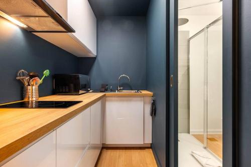 - une cuisine avec un comptoir, un évier et une cuisinière dans l'établissement Le Cocon de Claudie, à Nancy