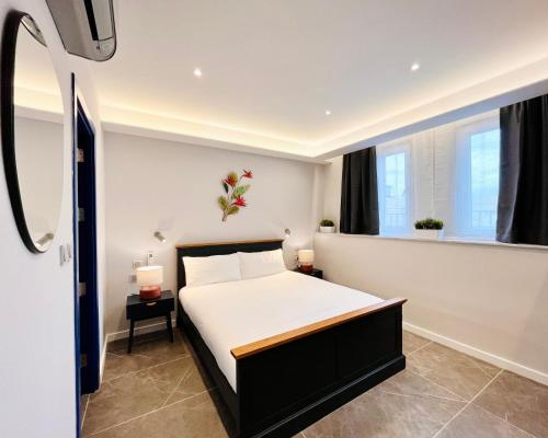Un dormitorio con una cama y dos ventanas. en Sliema 8 Bedroom House with Pool, en Sliema