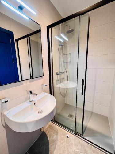 a white bathroom with a sink and a shower at Sliema 8 Bedroom House with Pool in Sliema