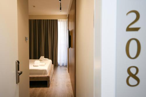 a hotel room with a bed and a window at Charm Hotel in Vlorë
