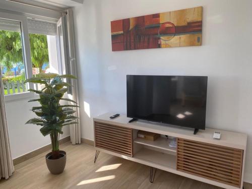 een woonkamer met een flatscreen-tv op een standaard bij Sea Escape in Almuñécar