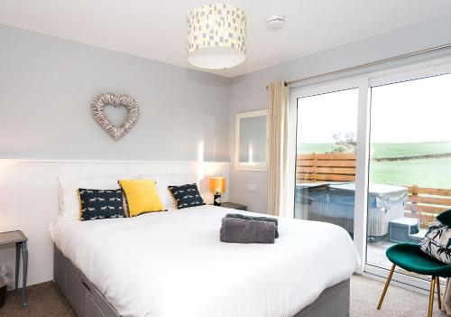 a bedroom with a bed and a large window at Beth's Bothy in Gatehouse of Fleet