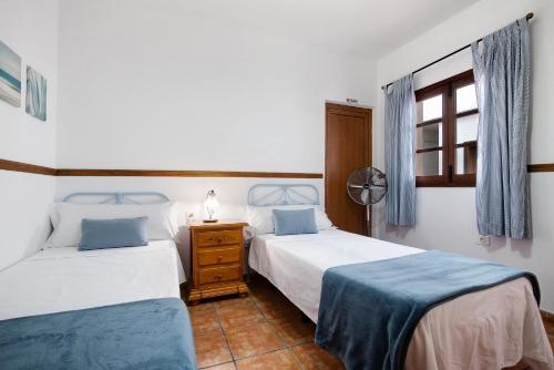 a bedroom with two beds and a window at Las Raíces in Pájara