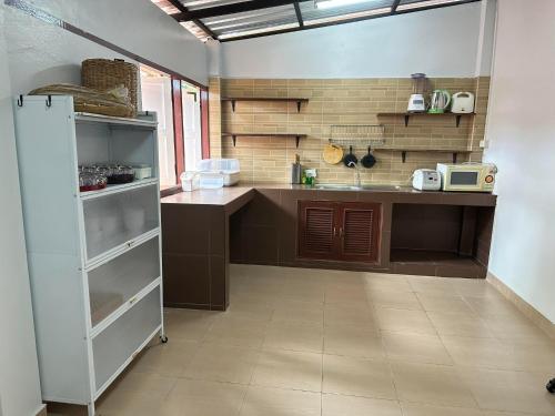 een keuken met een aanrecht en een koelkast. bij บ้านยายโฮมเทล Baan yai hometel in Nakhon Phanom