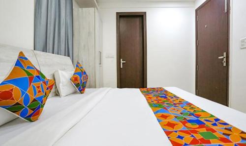 a bedroom with a bed with a colorful blanket on it at FabExpress Premium Room I in New Delhi