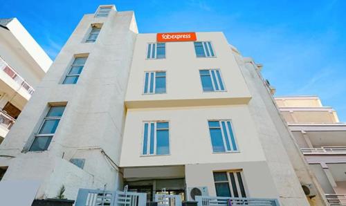a white building with a red sign on it at FabExpress Premium Room I in New Delhi
