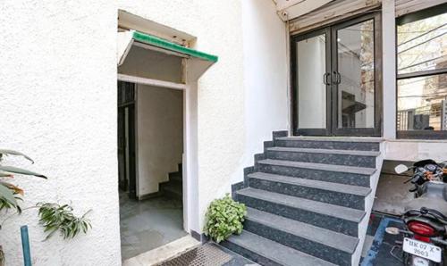 a scooter parked outside of a building with stairs at FabExpress Premium Room I in New Delhi
