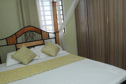 een slaapkamer met een bed met 2 kussens erop bij Cherry home in Nairobi