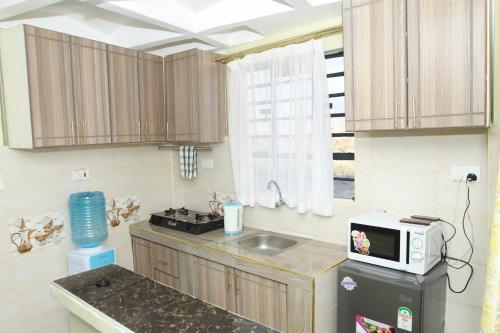una cucina con un lavandino e un microonde su un bancone di Cherry home a Nairobi