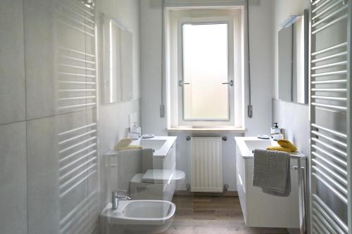 a bathroom with a sink and a toilet and a window at appartamento casa stefi n2 in Malcesine