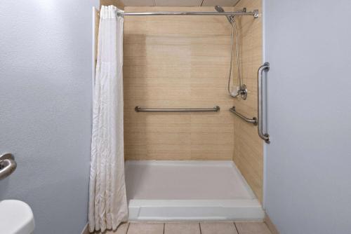 a shower with a white tub in a bathroom at Days Inn by Wyndham Queensbury/Lake George in Queensbury