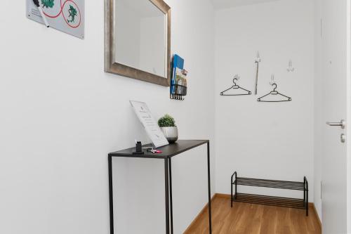 a mirror on a wall above a dresser in a room at ANYTIME - Riedlepark Apartments in Friedrichshafen