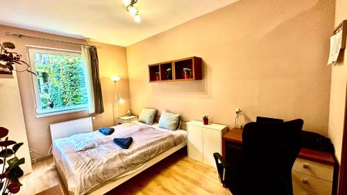a bedroom with a bed and a desk and a window at Benett apartman in Budapest