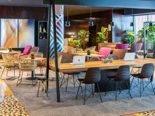 ein Restaurant mit Tischen und Stühlen mit Laptops darauf in der Unterkunft Novotel Barcelona Cornellà in Cornellà de Llobregat