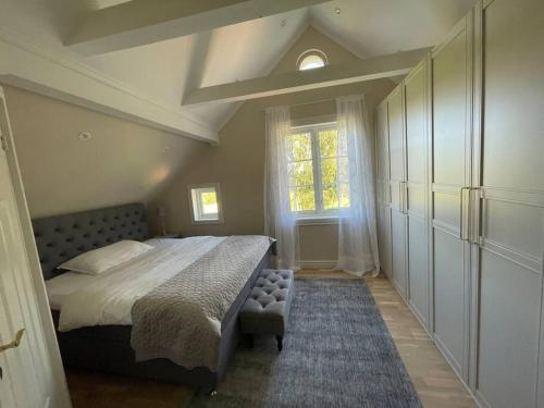 Un dormitorio con una cama grande y una ventana en Gård med egen sjö med bryggbåt, nyrenoverat!, en Katrineholm