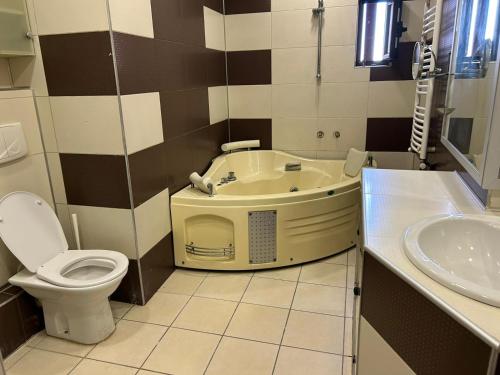 a bathroom with a tub and a toilet and a sink at Bucharest City Center Apartment in Bucharest