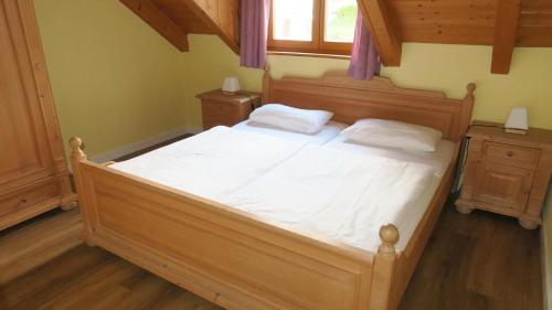 a bedroom with a bed with white sheets and a window at Appartementhaus Osserblick in Lohberg