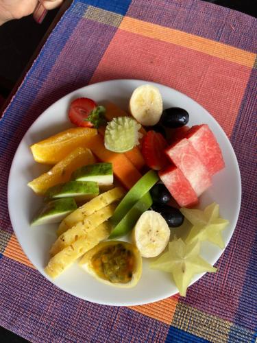 a plate of fruit and vegetables on a table at Kandalama Hostel in Dambulla