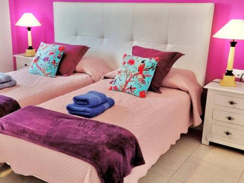 コラレホにあるAmore e Magia Corralejoの紫とピンクの部屋のベッド2台
