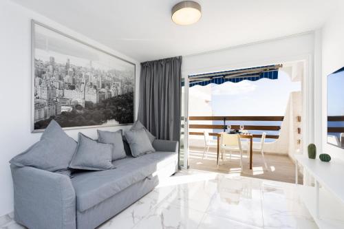 a living room with a couch and a table at Home2Book Bright Studio Ocean View Tabaiba in Tabaiba