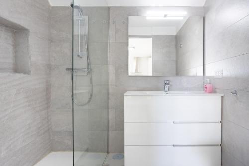 La salle de bains est pourvue d'une douche, d'un lavabo et d'un miroir. dans l'établissement Home2Book Bright Studio Ocean View Tabaiba, à Tabaiba