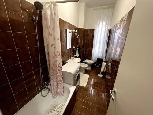 a bathroom with a tub and a toilet and a sink at Comodo appartamento a 2 minuti dalla metropolitana in Sesto San Giovanni