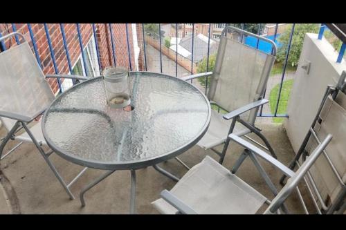a glass table and chairs on a balcony at Lovely 12th floor 2 bed flat in the heart ofLondon in London