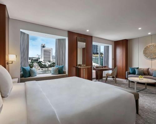 a bedroom with a large bed and a living room at Grand Hyatt Jakarta in Jakarta