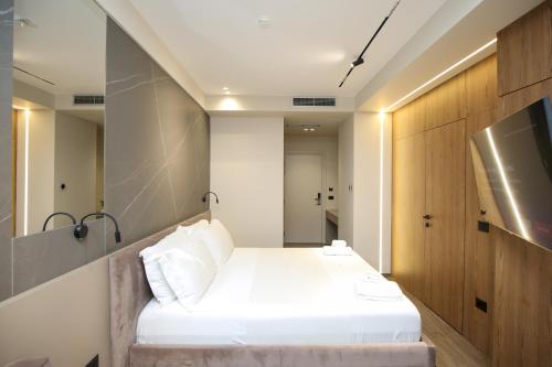 a small room with a bed and a tv at Charm Hotel in Vlorë