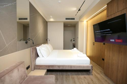 a room with a bed and a flat screen tv at Charm Hotel in Vlorë