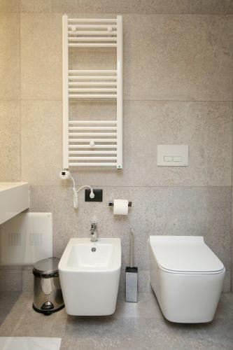 a bathroom with a white toilet and a sink at Charm Hotel in Vlorë