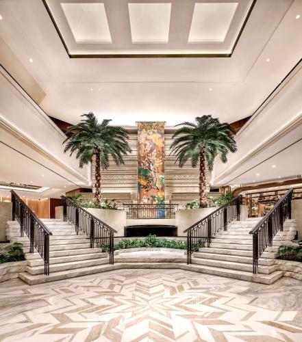 a lobby with stairs and palm trees at Grand Hyatt Jakarta in Jakarta