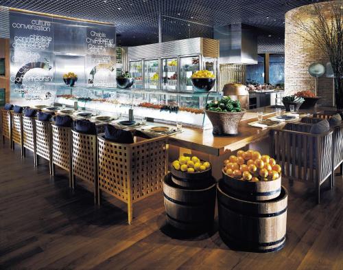 a restaurant with a buffet with fruit in barrels at Grand Hyatt Jakarta in Jakarta