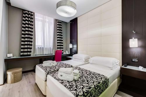 um quarto de hotel com duas camas e uma casa de banho em Best Western Cinemusic Hotel em Roma