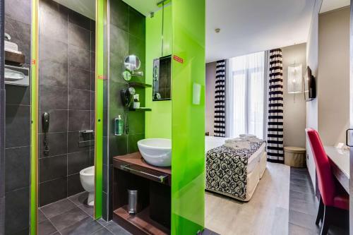 Best Western Cinemusic Hotel في روما: حمام أخضر مع حوض ومرحاض