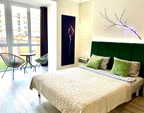 ヴィーンヌィツャにあるW&B на Коцюбинськогоのベッドルーム1室(緑のヘッドボード付きの大型ベッド1台付)