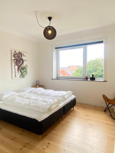 een slaapkamer met een groot bed en een raam bij (id.023) Spangsberggade 24. 2 tv in Esbjerg