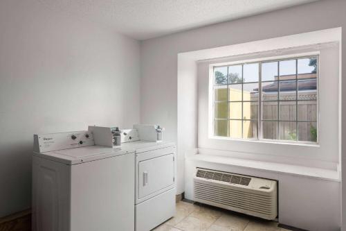 a laundry room with a window and an air conditioner at Super 8 by Wyndham Harbison/Parkridge Hospital in Columbia