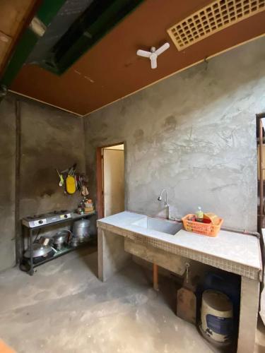 een keuken met een spoelbak en een fornuis bij Perucho-Silang Guest House in Mabini
