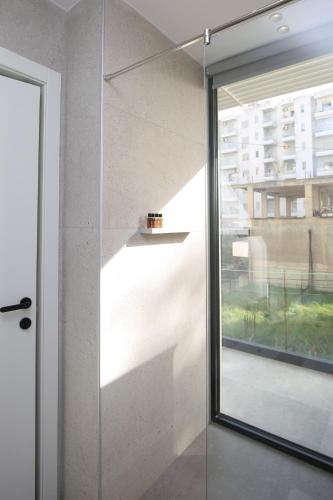 a glass door in a room with a window at Charm Hotel in Vlorë