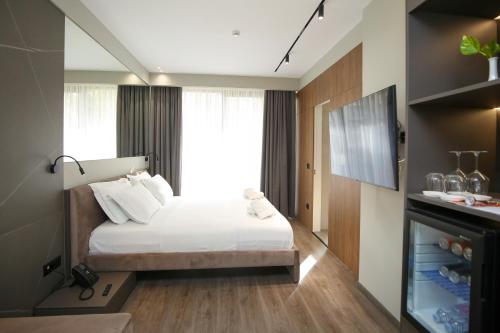 a bedroom with a bed and a large window at Charm Hotel in Vlorë