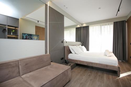 a bedroom with a large bed and a couch at Charm Hotel in Vlorë