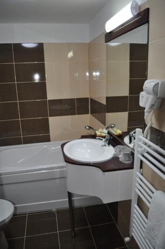 a bathroom with a sink and a bath tub at Hotel Valea cu Pesti in Căpăţîneni-Ungureni