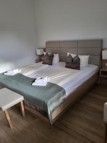 ein Schlafzimmer mit einem großen Bett und einem Stuhl in der Unterkunft Bootshaus in Bedekaspel