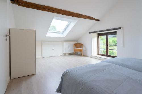 a white bedroom with a bed and a window at Le jardin du vieux moulin 6A in Rendeux