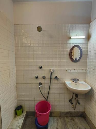 a bathroom with a sink and a bucket at AMIT HOTEL in Kolkata