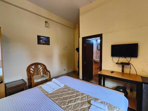 a bedroom with a bed and a desk and a television at AMIT HOTEL in Kolkata