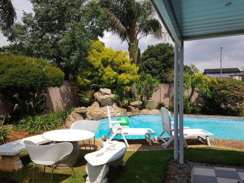a patio with a table and chairs and a pool at The Link on Elgin in Kempton Park
