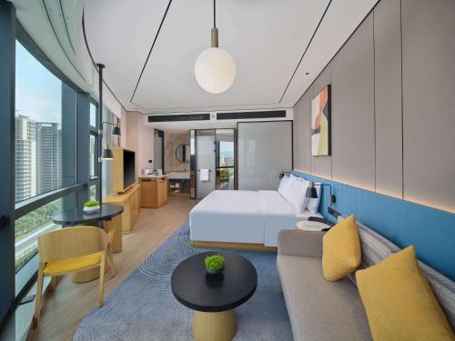 um quarto de hotel com uma cama e um sofá em Hilton Garden Inn Xiamen Tong'An em Xiamen